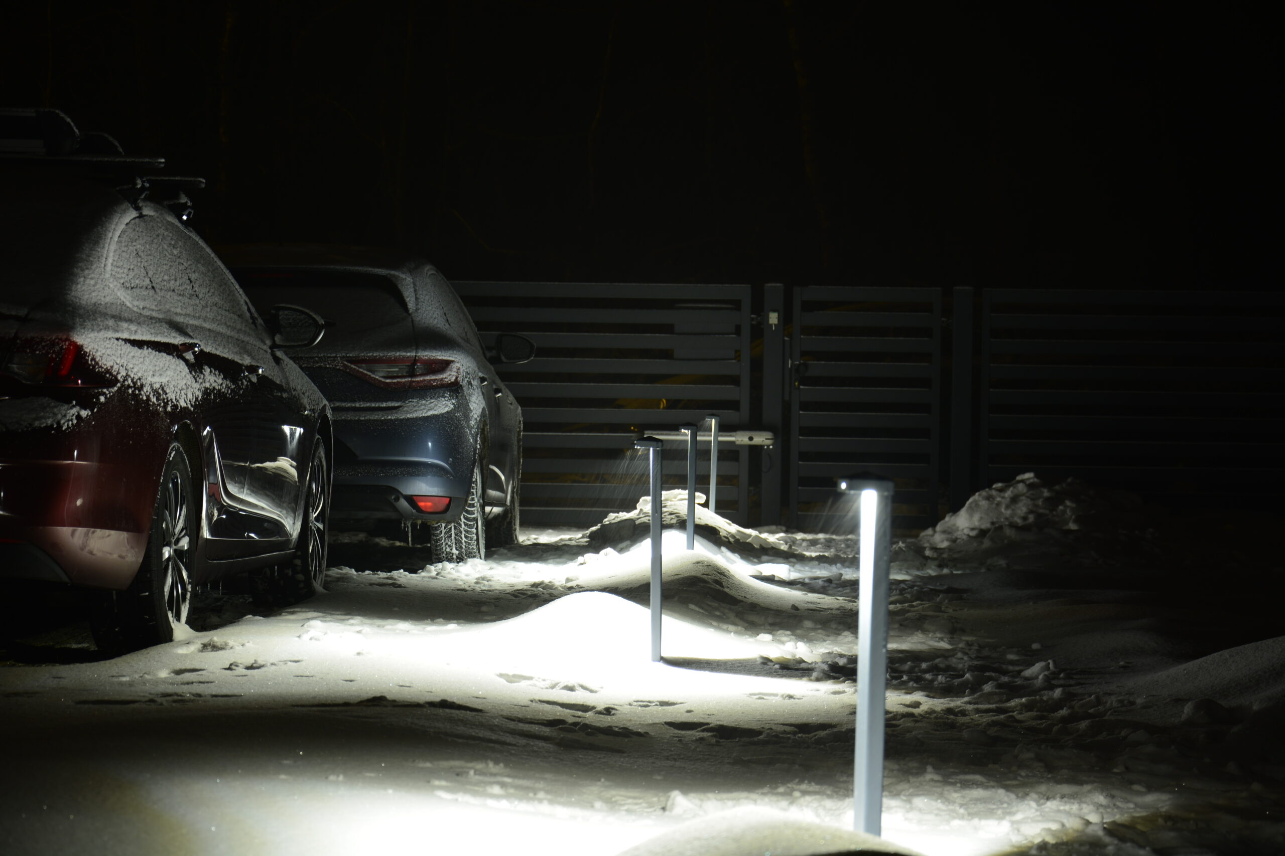 Lampy ogrodowe oświetlają podjazd i ścieżkę do domu.